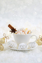 Obraz na płótnie Canvas Blurred background of winter frost and Christmas chocolate spice beverage with sweets in white cups