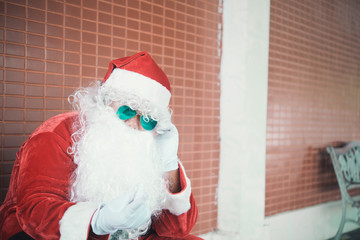 Santa claus sit on the bench and listen music,Thailand people,Sent happiness for children,Merry christmas,Welcome to winter