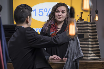Male customer buying clothes from a sales clerk