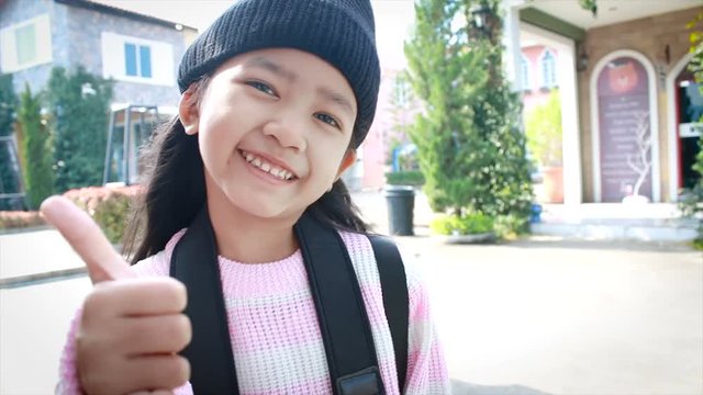 4K Asian little girl smile and showing thumbs up with happiness for holiday travel concept
