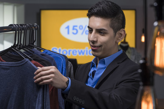Young man shopping for new clothes during a sale