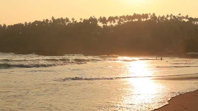 Tropical sand beach and sea water wave at Mirissa during sunset, Sri Lanka