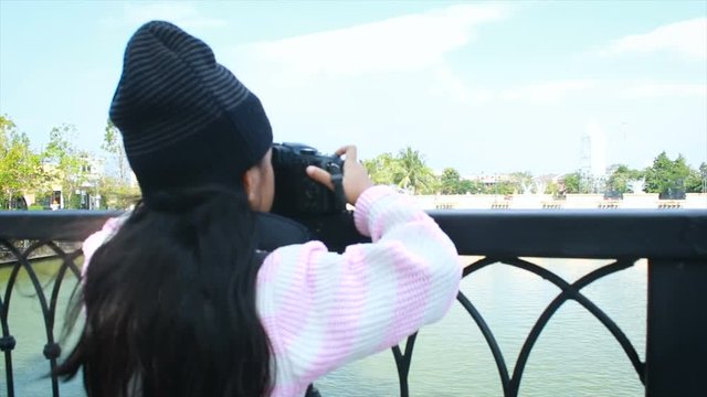 4K Asian little girl taking photo by shooting camera and show thumbs up with happiness, concept for holiday travel