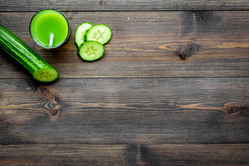 Green detox beverage with cucumber, asparagus, zucchini on dark wooden background top view copyspace