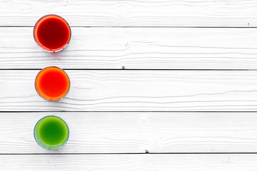 Wellness elements. Colorful detox drinks with vegetables  on white wooden background top view copyspace
