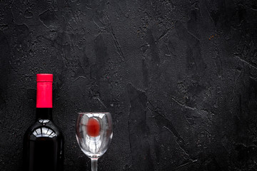 Drink red wine. Bottle and glass on black background top view copyspace