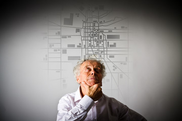 Old man is looking for a route on the city map.