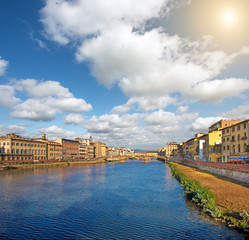 Beautiful city view with the famous medieval stone bridge Ponte Vecchio over the Arno river in Florence, Italy at sunny day. Place of pilgrimage for tourists.