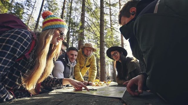 Group of people discussing over map in forest