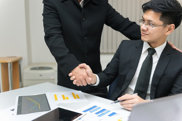 Two Asian businessmen success concept,Thailand employee happy from work finished,Shaking hands after finish work