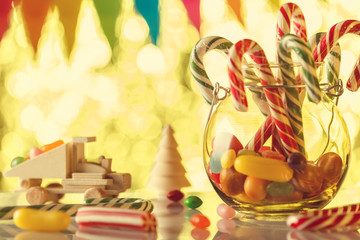 Fototapeta premium Cane caramel, in a glass jar. All for a sweet nice holiday. Children's card. Ready greeting. Retro toning.