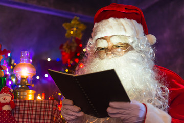 Santa claus read a book at night in the house,The light from the book,Using the light from the lantern room