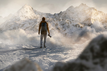 Wanderer steht vor schneebedecktem Gebirge - obrazy, fototapety, plakaty