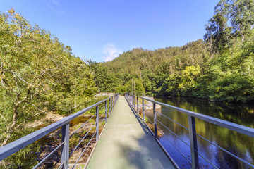 Longitudinal view of a bridge over a wide part of the mountain stream called 