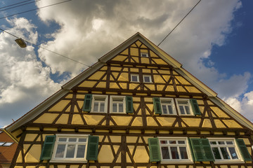 The frontside of an old house below a cloudy sky