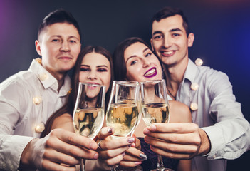 Couple celebrating New Year's eve drinking champagne and lighting up sparklers on masquerade party