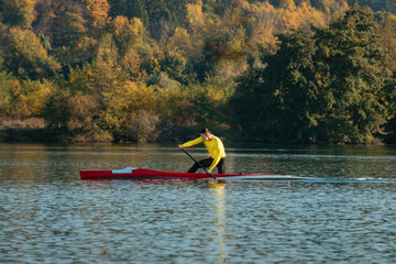 Strong young man with his kayak on a sunny day on a lake. 