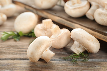Fresh champignon mushrooms on wooden table