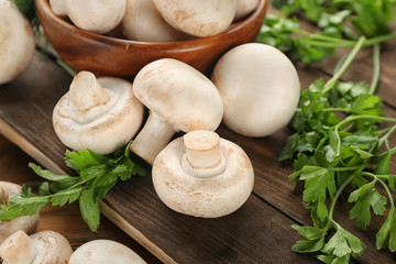 Fresh champignon mushrooms on wooden table