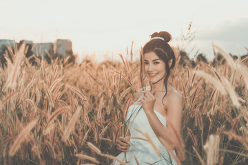 Portrait of beautiful asian woman wear white dress in the field on sunset,Thailand people