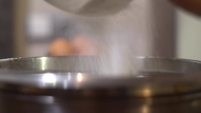 The flour is sieved through an iron sieve