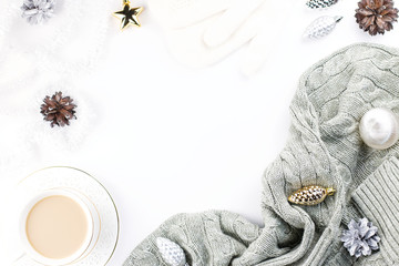 Christmas concept flat lay with winter warm clothes, christmas decorations and hot drink on white background.