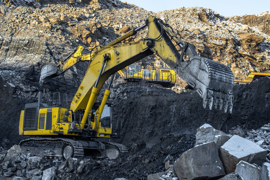 Big yellow dump truck and excavator in the coal mine, fisheye
