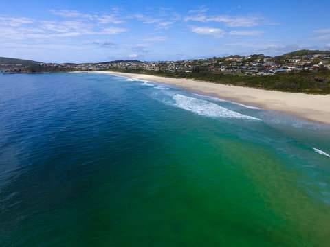 Luftbild mit Blick auf einen Sand-Badestrand mit interessantem Farbenspiel des Meer