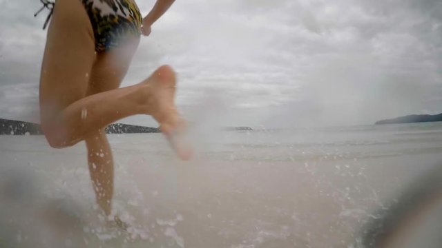 Speed ramping of pretty mature woman wearing a bikini and sunglasses splashing water with one hand towards the camera.