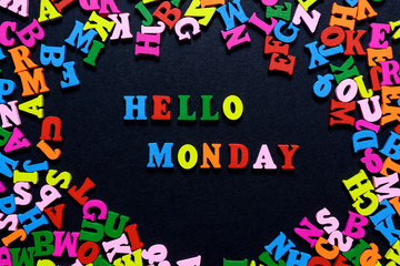 concept design - the word HELLO MONDAY from multi-colored wooden letters on a black background, creative idea