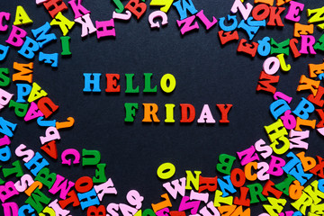 concept design - the word HELLO FRIDAY from multi-colored wooden letters on a black background, creative idea