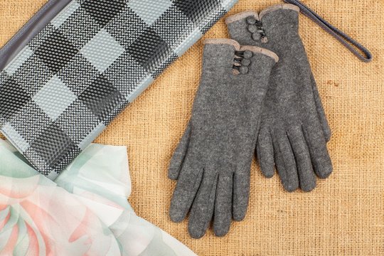 Scarf, handbag and gloves isolated on linen background.