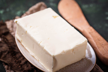 Fresh butter and knife on concrete background