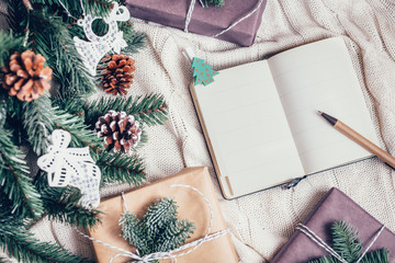 Composition with Christmas decorations gift notepad fir tree on white background