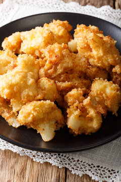 fried fresh cauliflower in breadcrumbs closeup. vertical