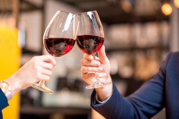 Clinking glasses with wine during the business lunch at the restaurant