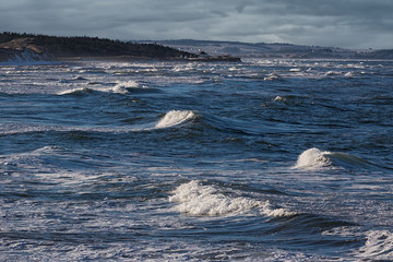 Waves rolling in along the shoreline of Cavendish beach in Prince Edward Island National Park, PEI, Canada.