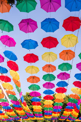 A field of open multi colored umbrellas used as sun protection at a public place somewhere at Torremolinos, Spain (different views) - obrazy, fototapety, plakaty