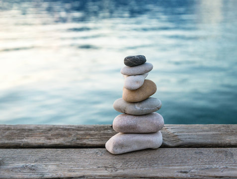 Harmony and relaxation concept, balanced stones pyramid on wooden pier