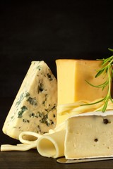 Different types of cheeses on the kitchen table. Preparation of snacks. Healthy food.