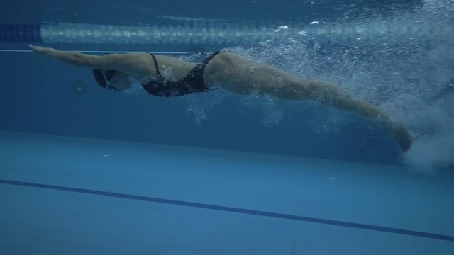 Woman jumping in transparentwater on floating poolunder water view 60 fps