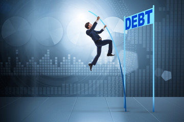 Businessman pole vaulting over debt in business concept