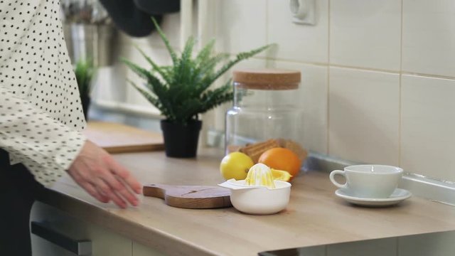 Pregnant woman preparing orange juice in her kitchen
