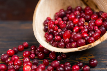 Close up of rowan berries in wooden plate on old wooden desk