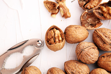 Walnut kernels and whole walnuts on table with a nutcracker