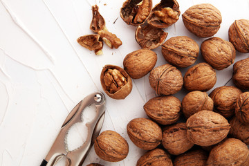 Walnut kernels and whole walnuts on table with a nutcracker
