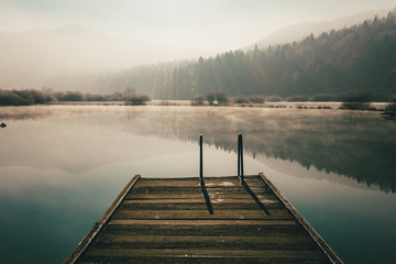 Mysterious lake on an early winter morning photographed in backlight in central Slovenia