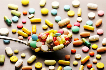 Colorful medicine pills in spoon