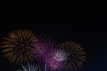 Brightly colorful fireworks in the night sky. New Year celebration fireworks