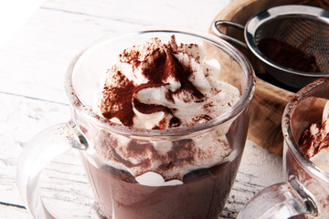 Hot chocolate or coffee with whipped cream in glass.
